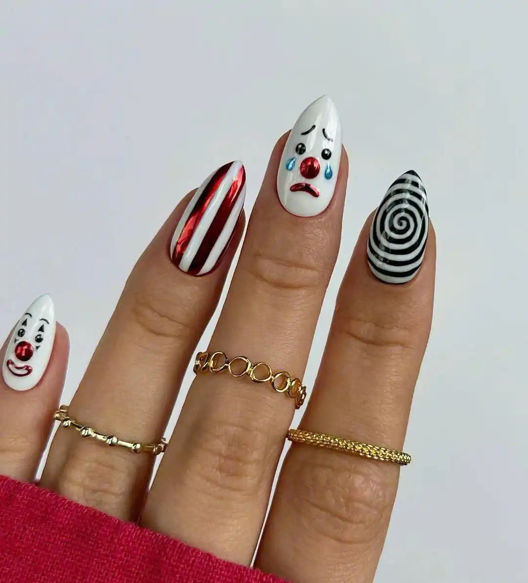 Halloween press-on nails with cute clown faces, red stripes, and black spiral designs