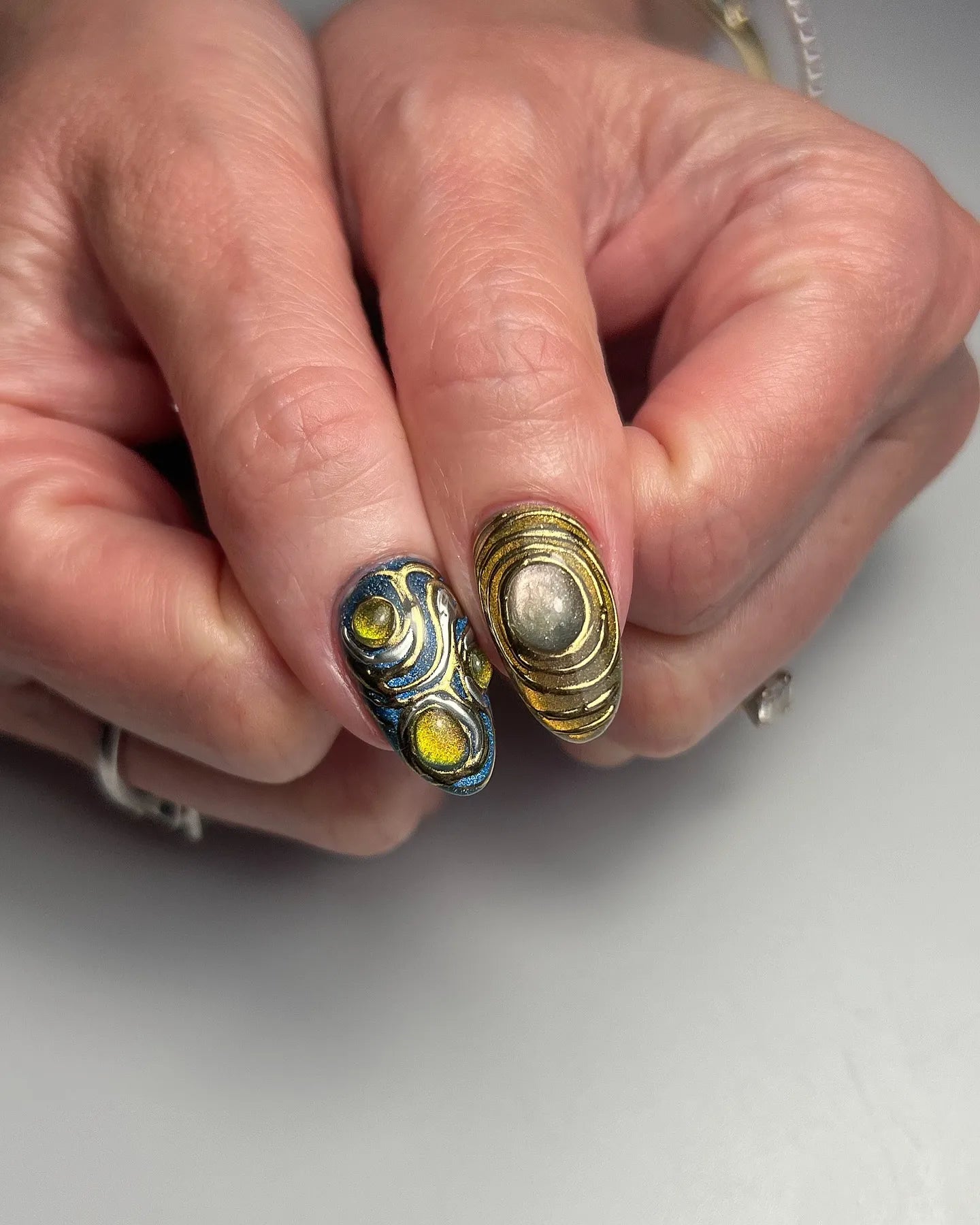 Handmade 3D metallic press-on nails with gemstone accents and ancient artifact design