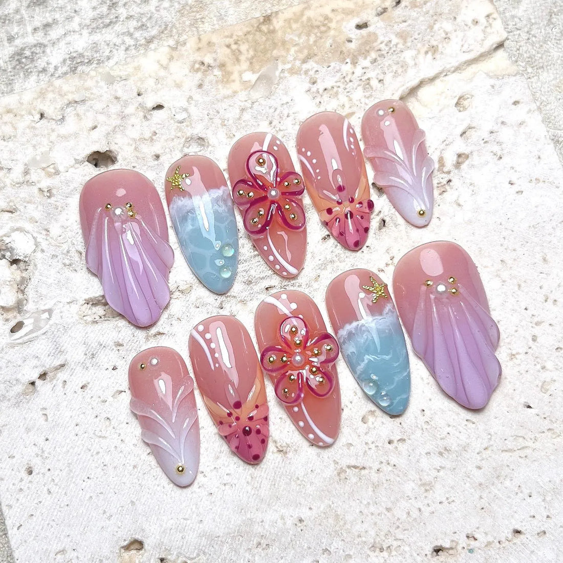 Handmade press-on nails with pink sea shell, hibiscus flower, and ocean beach designs