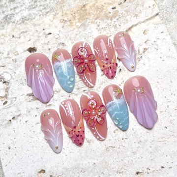 Handmade press-on nails with pink sea shell, hibiscus flower, and ocean beach designs