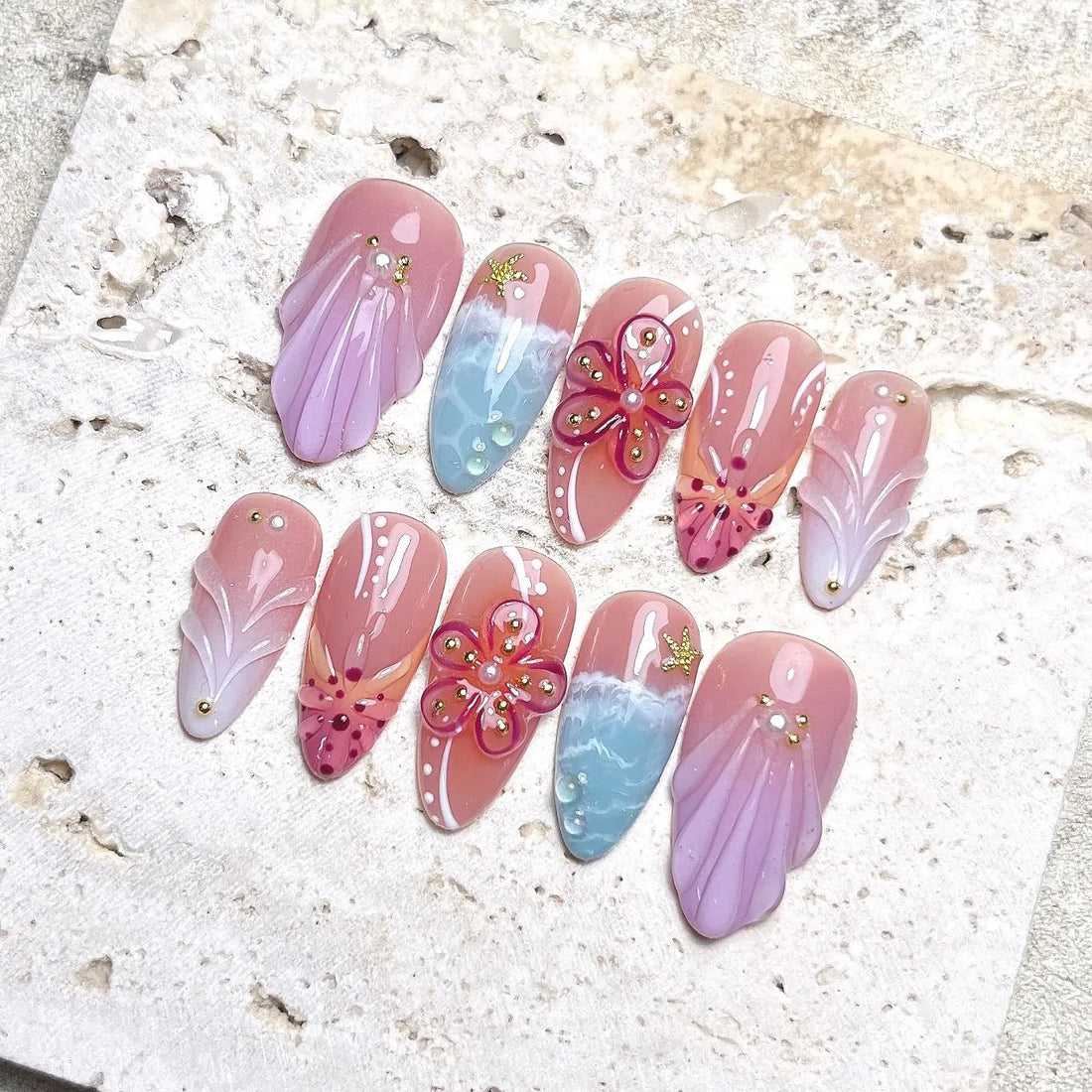 Handmade press-on nails with pink sea shell, hibiscus flower, and ocean beach designs