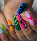 Hand with long stiletto press-on nails in colorful neon abstract 3D chrome designs