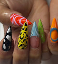 Hand holding handmade long stiletto press-on nails with abstract neon and chrome designs