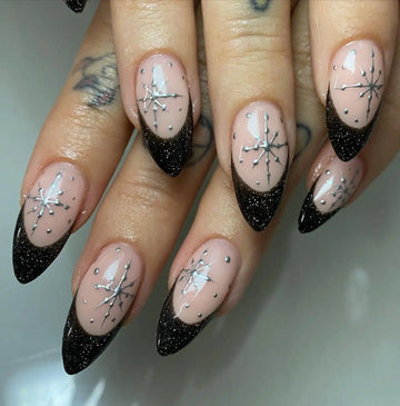 Handmade black glitter French tip press-on nails with silver starburst design