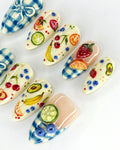 Handmade press-on nails with blue gingham and colorful 3D mixed fruit designs.