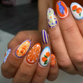 Handmade press-on nails with Mediterranean seafood, fruit, and floral designs in bright colors