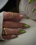 Hand with handmade green beetle wing press-on nails and gold chrome accents