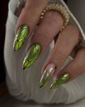 Hand with long handmade press-on nails, metallic green beetle wing design, gold chrome accents