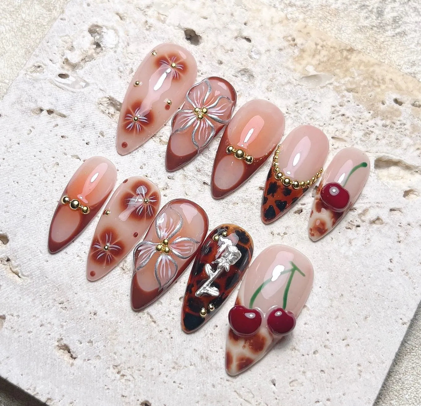 Handmade press-on nails with brown leopard, floral, cherry, and gemstone 3D designs