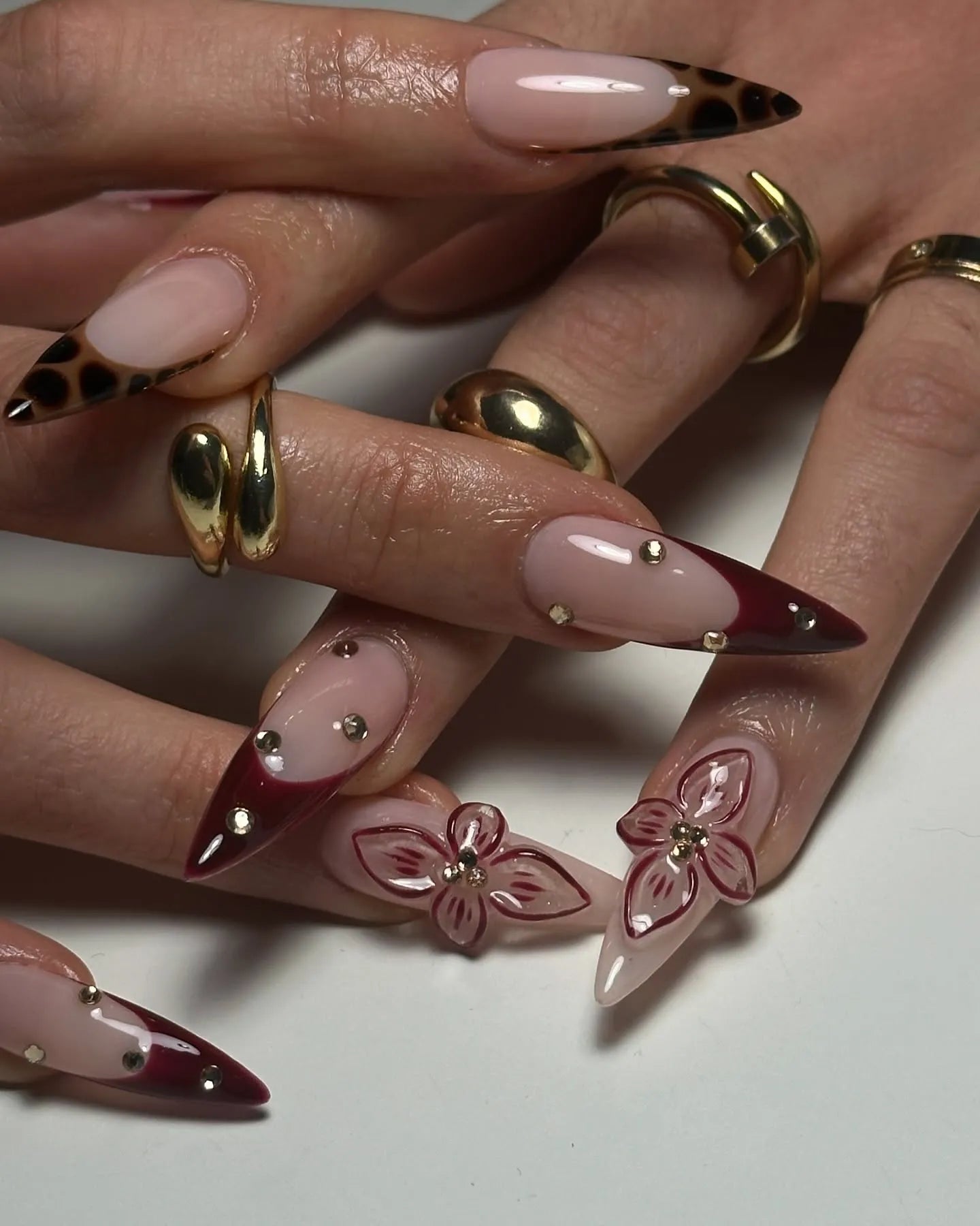 Handmade burgundy French press-on nails with leopard print, 3D floral accents, and gold studs