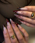 Handmade stiletto press-on nails with burgundy tips, leopard print, gold studs, and 3D floral accents