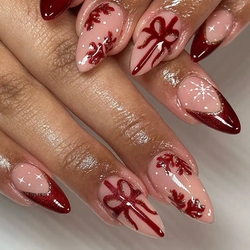 Handmade press-on nails with red glitter, snowflake, ribbon, and Christmas designs