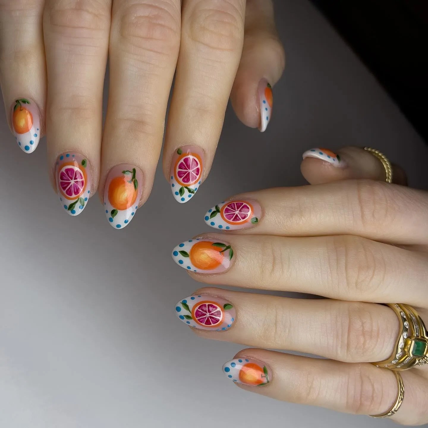 Handmade press-on nails with orange and grapefruit fruit art, blue polka dots, almond shape