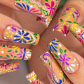 Handmade press-on nails with vibrant folk art floral summer designs in bright colors.