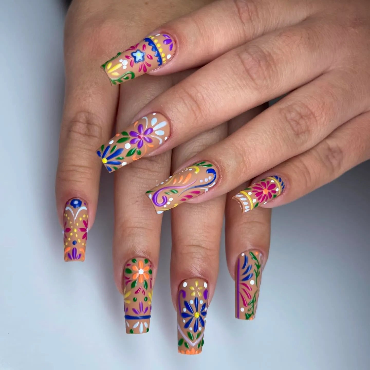 Handmade press-on nails with vibrant floral folk art design in summer colors