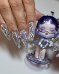 Hand with stiletto press-on nails, chrome purple metallic finish, 3D flower accents