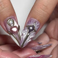 Handmade iridescent 3D press-on nails with metallic heart, pearl, star, and bow designs