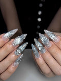 Handmade silver metallic press-on nails with celestial and heart designs, long stiletto shape.