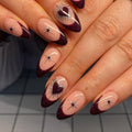 Handmade press-on nails with dark burgundy French tips, silver chrome hearts, and star designs.