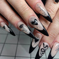 Handmade long stiletto press-on nails with black French tips, gothic heart, rose, and spider designs.
