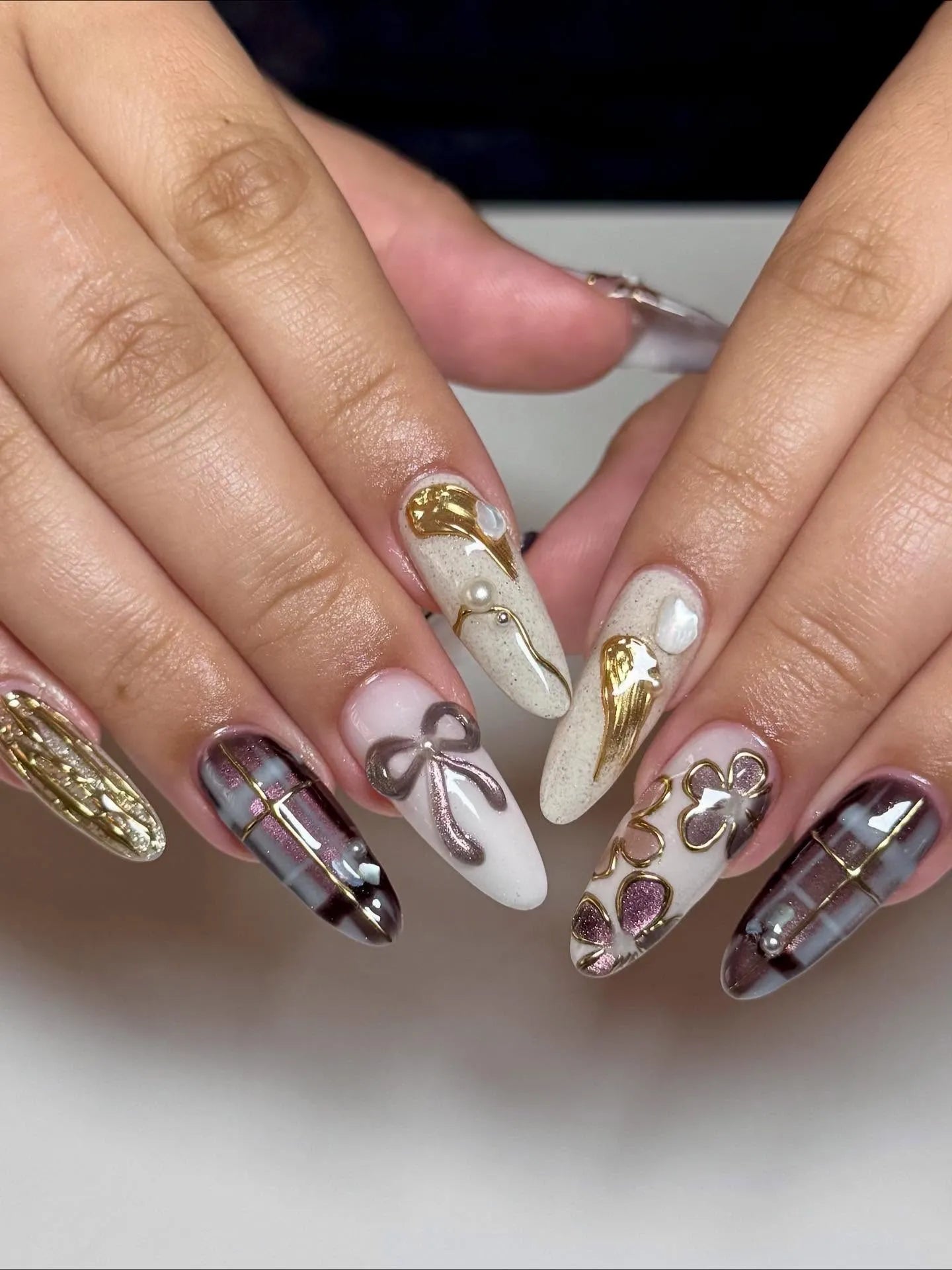 Handmade press-on nails with dark tartan plaid, 3D metallic bows, and gold floral accents