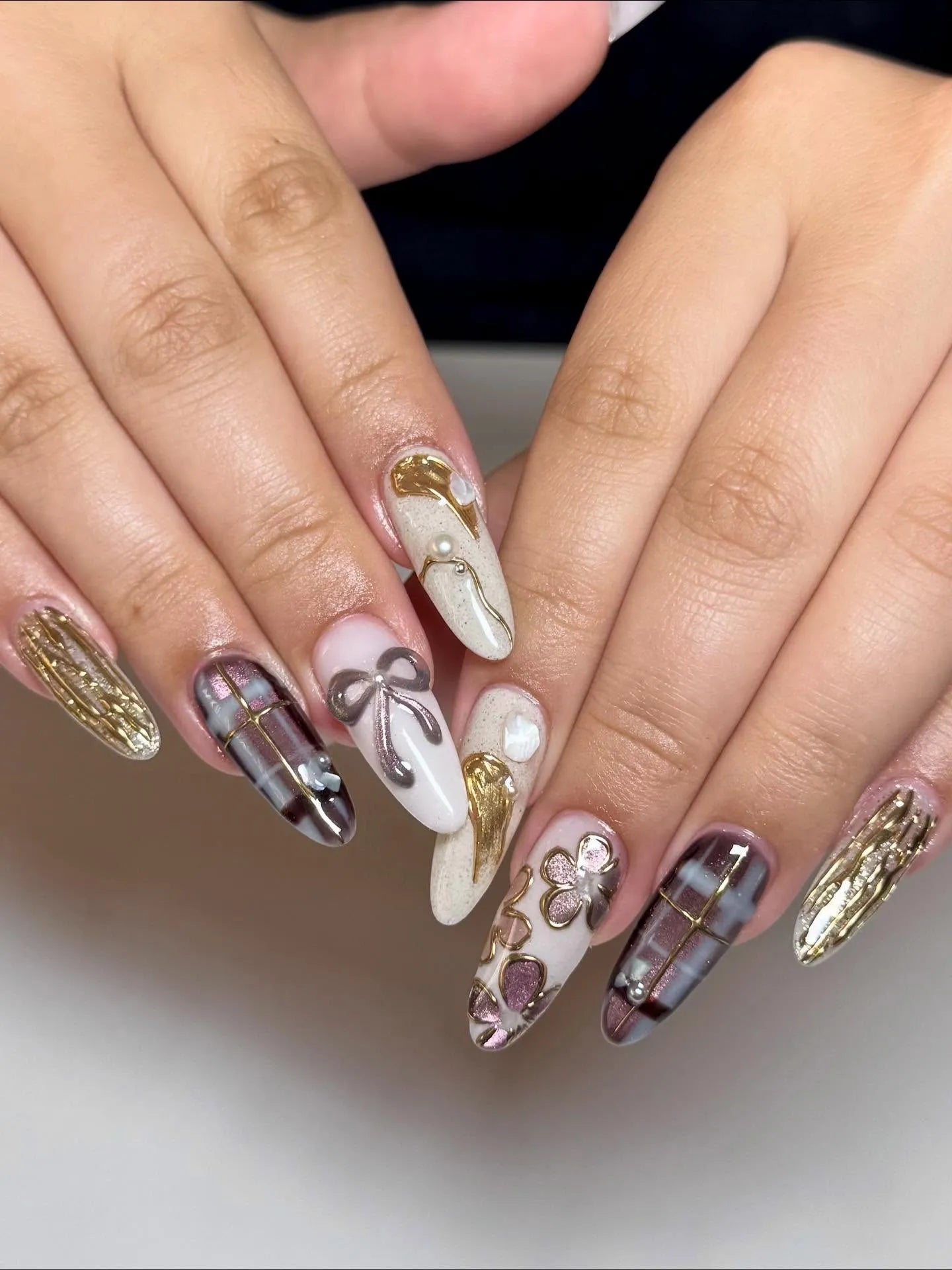 Handmade press-on nails with dark tartan plaid, gold metallic bows, and floral accents.