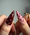 Handmade deep red and pink 3D floral press-on nails with gemstone accents on hands