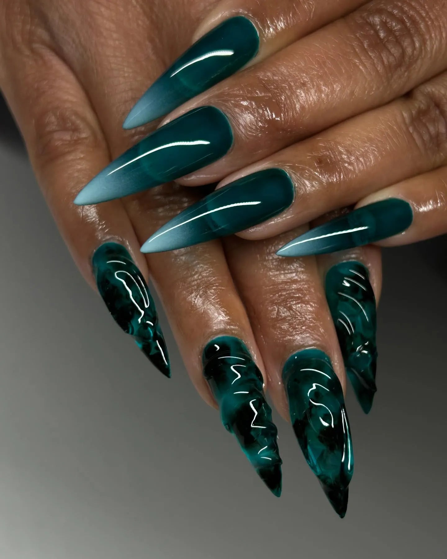 Hand with handmade emerald green stiletto press-on nails, 3D sea glass textured design