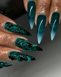 Hand with emerald green stiletto press-on nails, 3D textured and sea glass effect