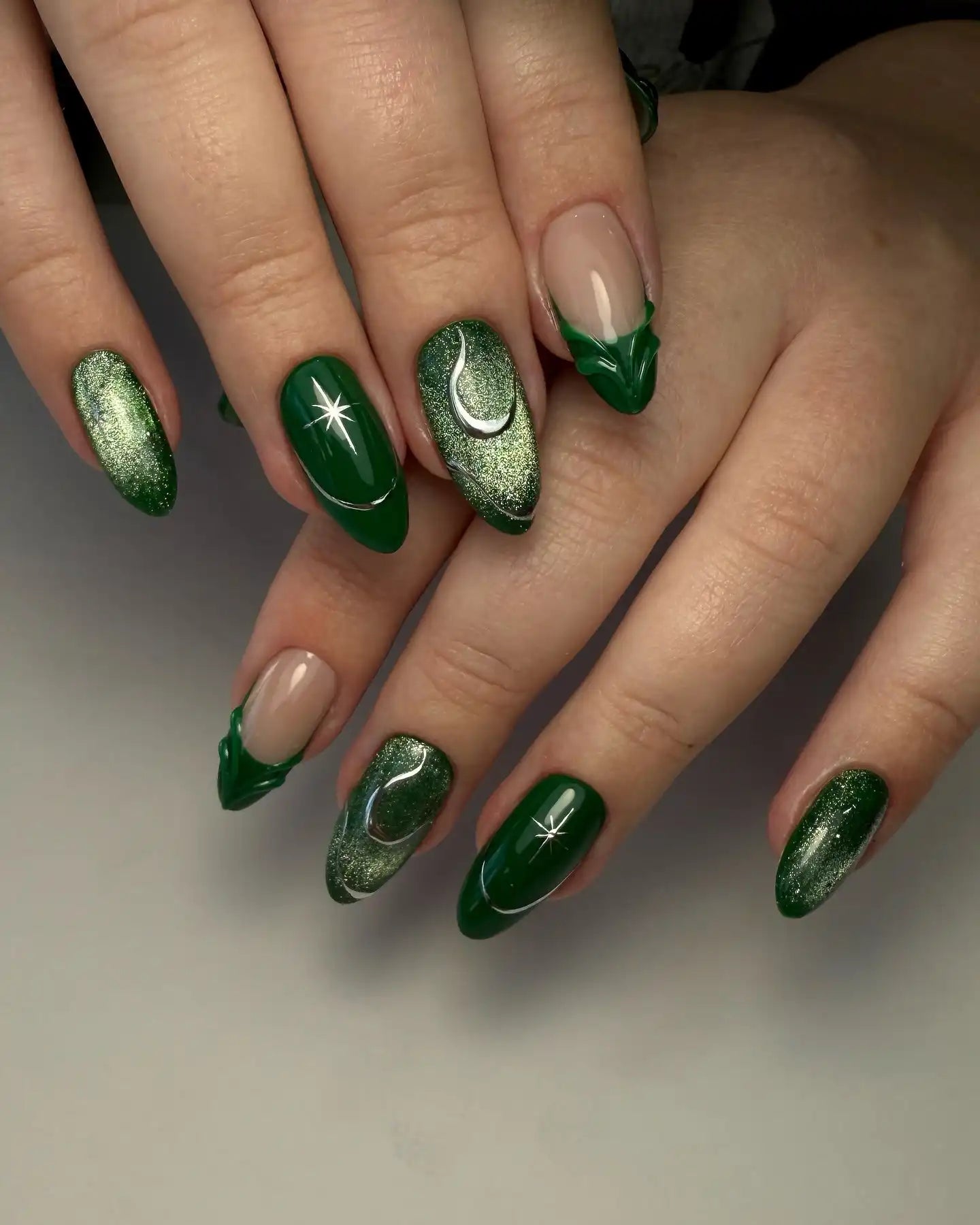 Handmade emerald green press-on nails with celestial moon and star designs