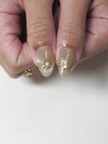 Handmade press-on nails with green and gold vine, rose, and cat eye design.