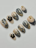 Handmade grey and nude press-on nails with gold starburst and celestial marble designs