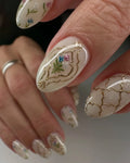 Handmade press-on nails with gold trellis design and vintage floral accents, almond shape.