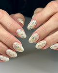 Handmade press-on nails with vintage floral and gold trellis designs on almond shapes.