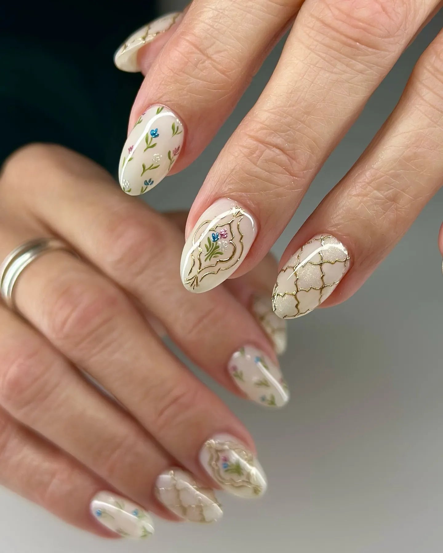 Handmade press-on nails with vintage floral and gold trellis designs on almond shapes.