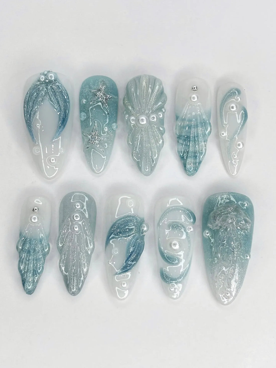 Handmade blue seafoam press-on nails with 3D starfish, shell, and glitter ocean designs.