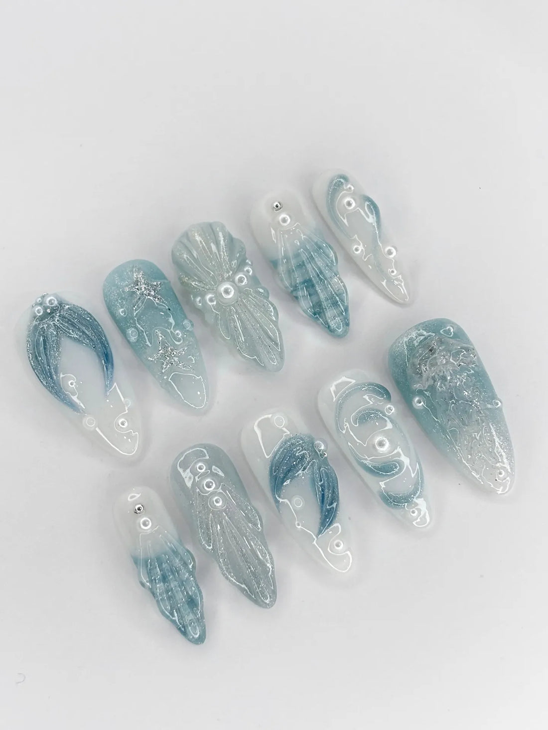 Handmade blue seafoam press-on nails with 3D starfish, shell, and glitter ocean designs.