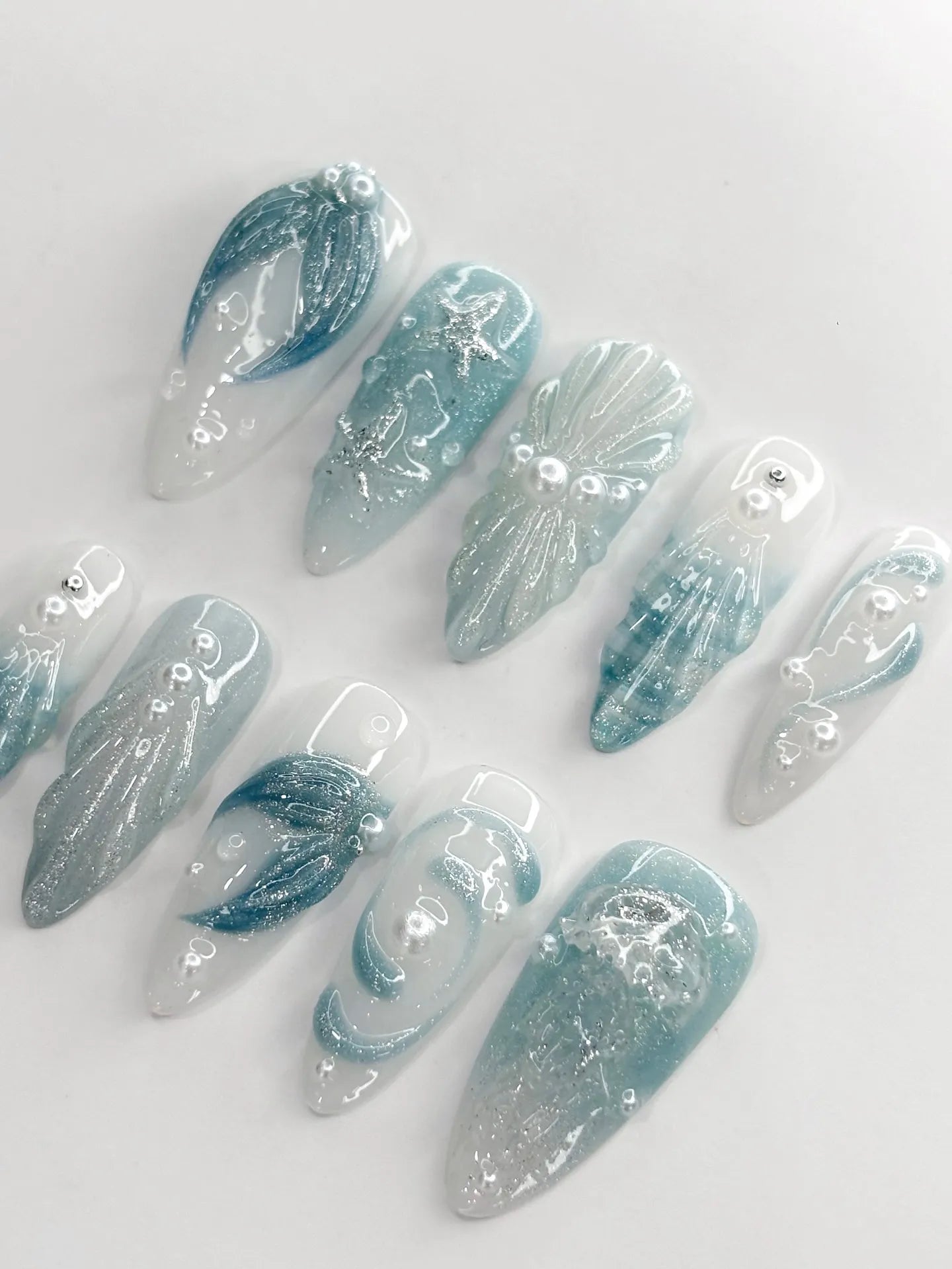 Handmade blue and seafoam press-on nails with 3D starfish, shell, and pearl ocean designs.