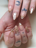 Handmade gold filigree press-on nails with pearlescent finish and black polka dots