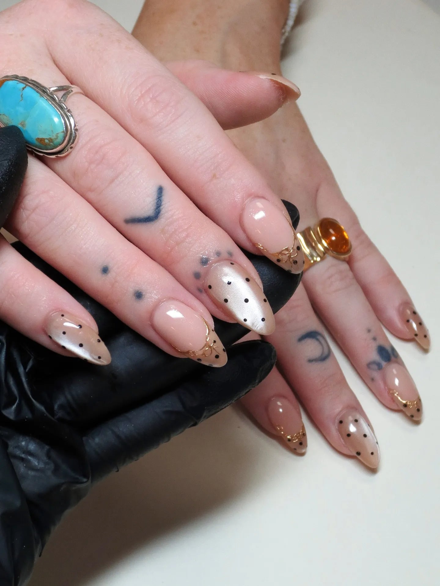 Handmade gold filigree press-on nails with pearlescent beige and black polka dot design.