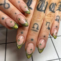 Handmade gold and moss green shimmer French tip press-on nails with starburst accents