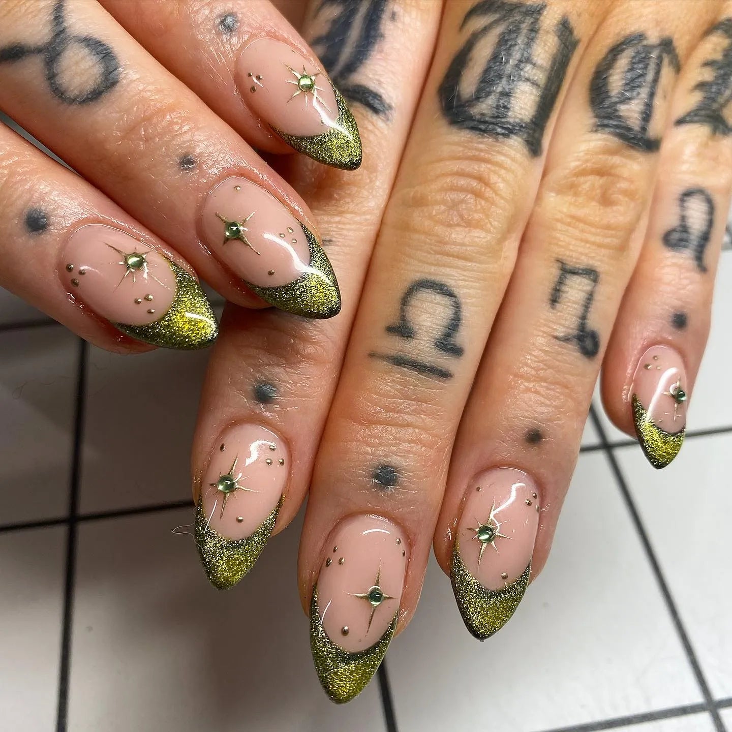 Handmade gold and moss green shimmer French tip press-on nails with starburst accents