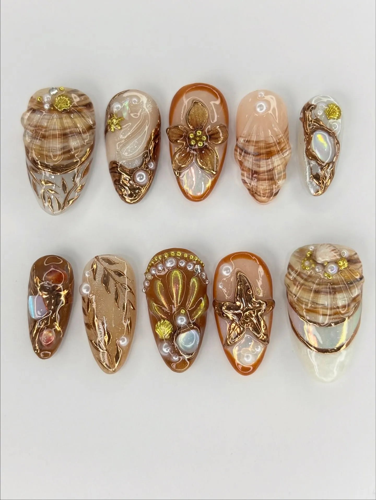 Handmade beach-themed press-on nails with gold starfish, seashell, and ocean-inspired designs.