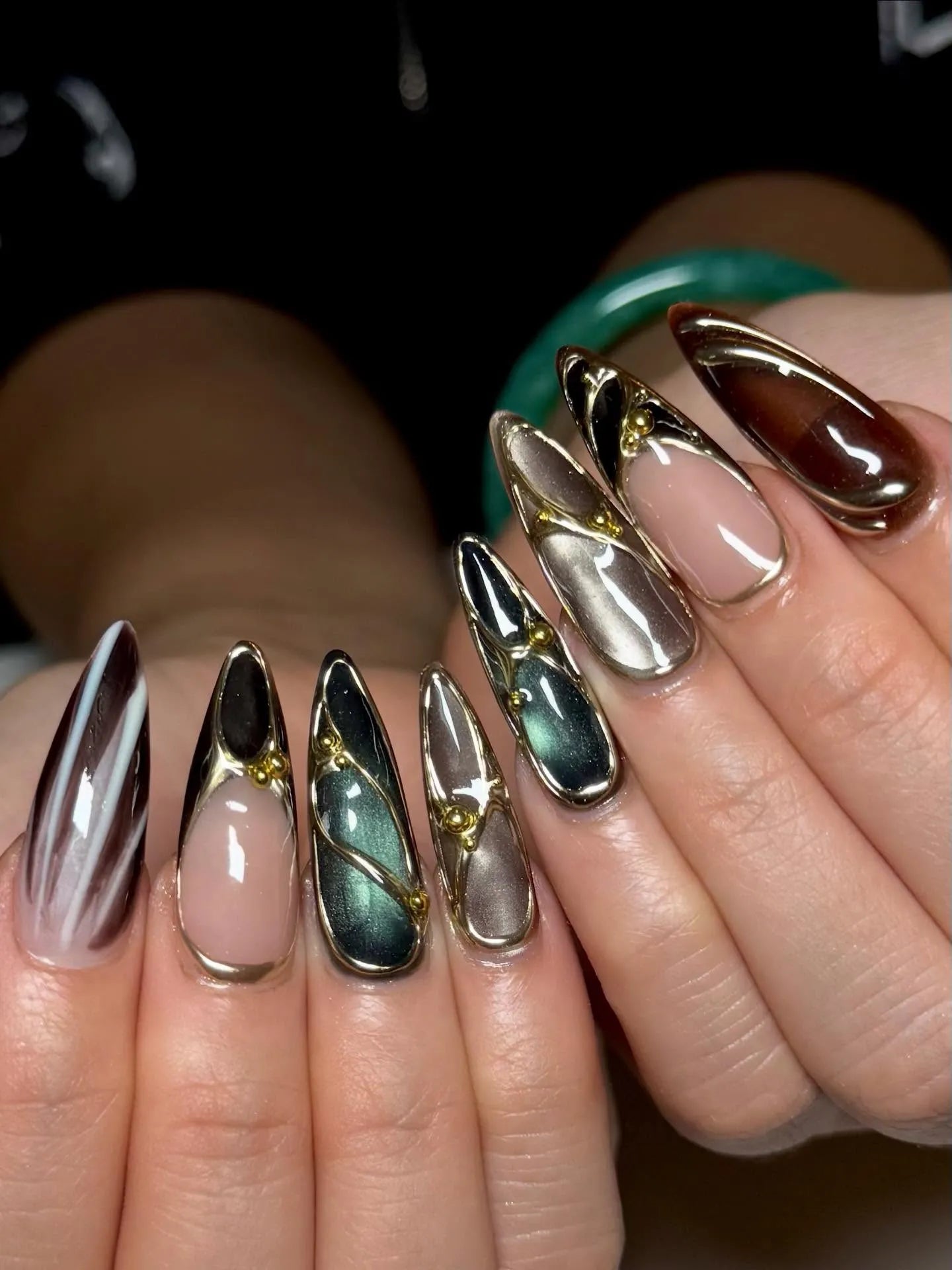 Handmade metallic stiletto press-on nails with jewel tones and gold chrome accents
