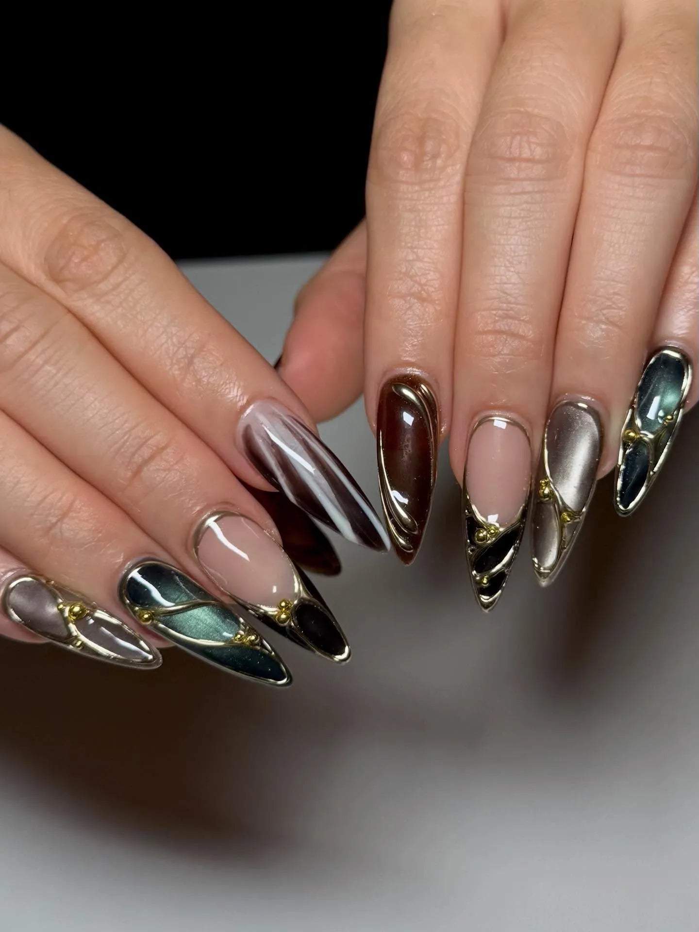 Handmade stiletto press-on nails with chrome, jewel tone, and metallic aura accents