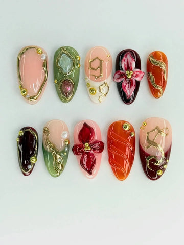 Handmade press-on nails with 3D red floral, green, gold filigree, and jewel accents.