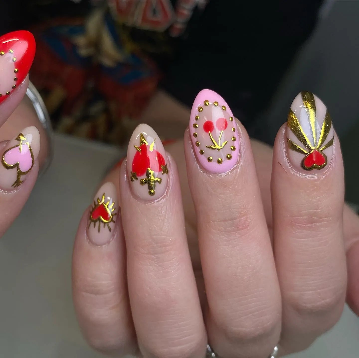 Handmade press-on nails with red sacred heart, gold dagger, and cherry gothic designs