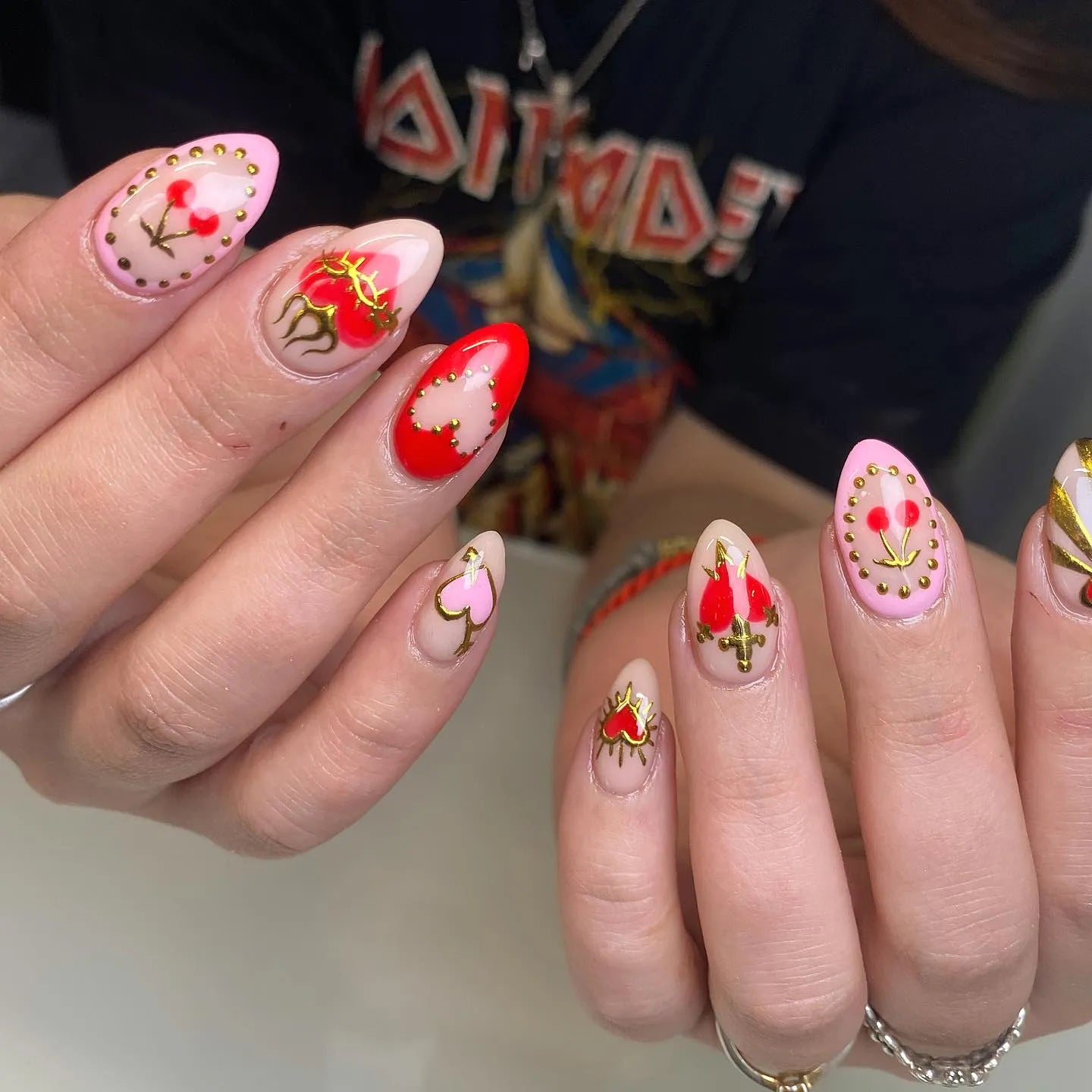 Handmade press-on nails with red, pink, and gold sacred heart gothic designs