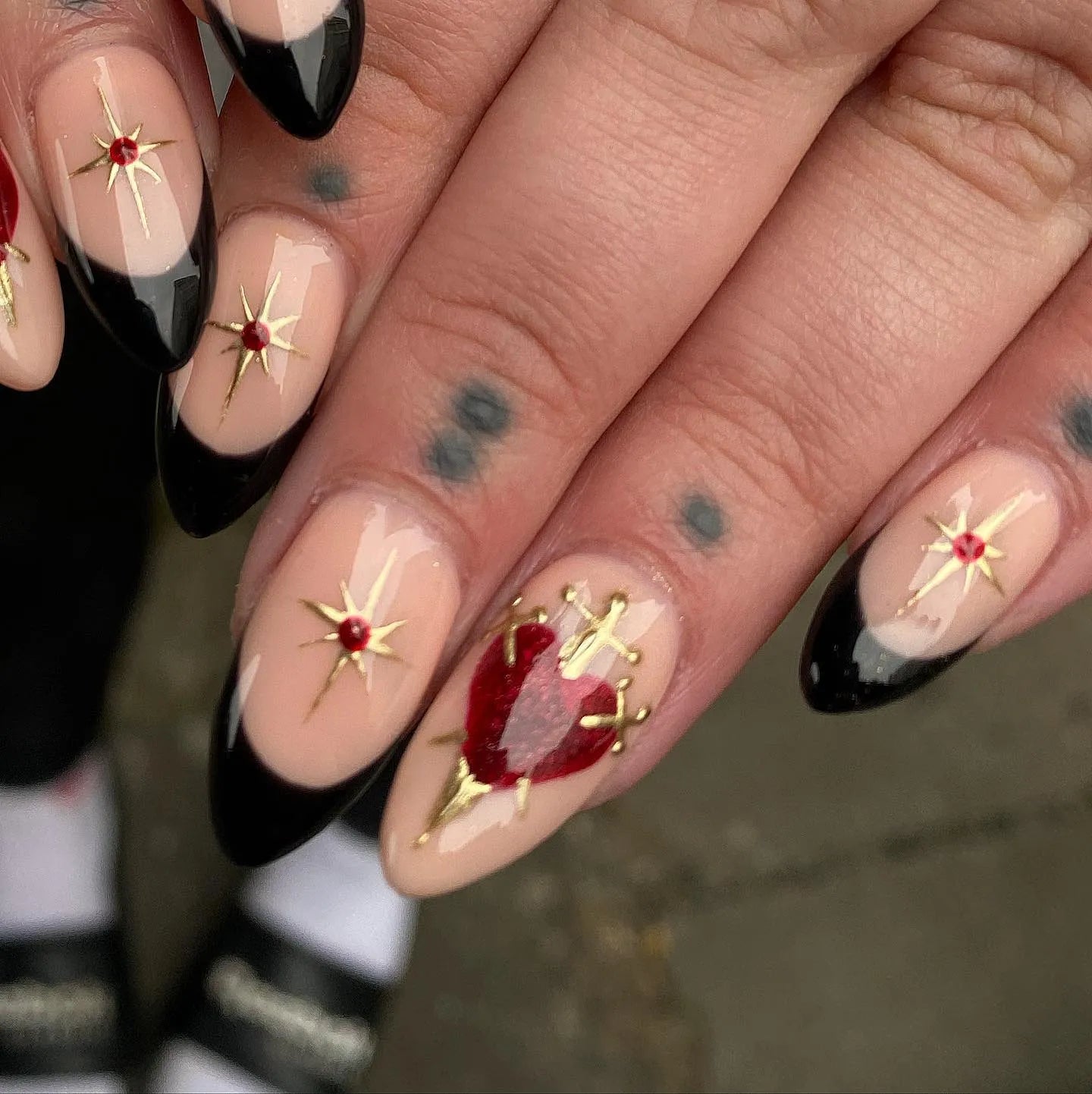 Handmade black French tip press-on nails with gold star accents and red heart design