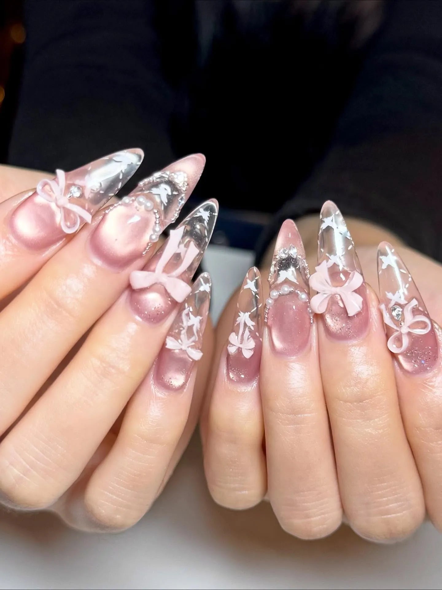 Handmade stiletto press-on nails with pink bows, pearl accents, swan and star designs